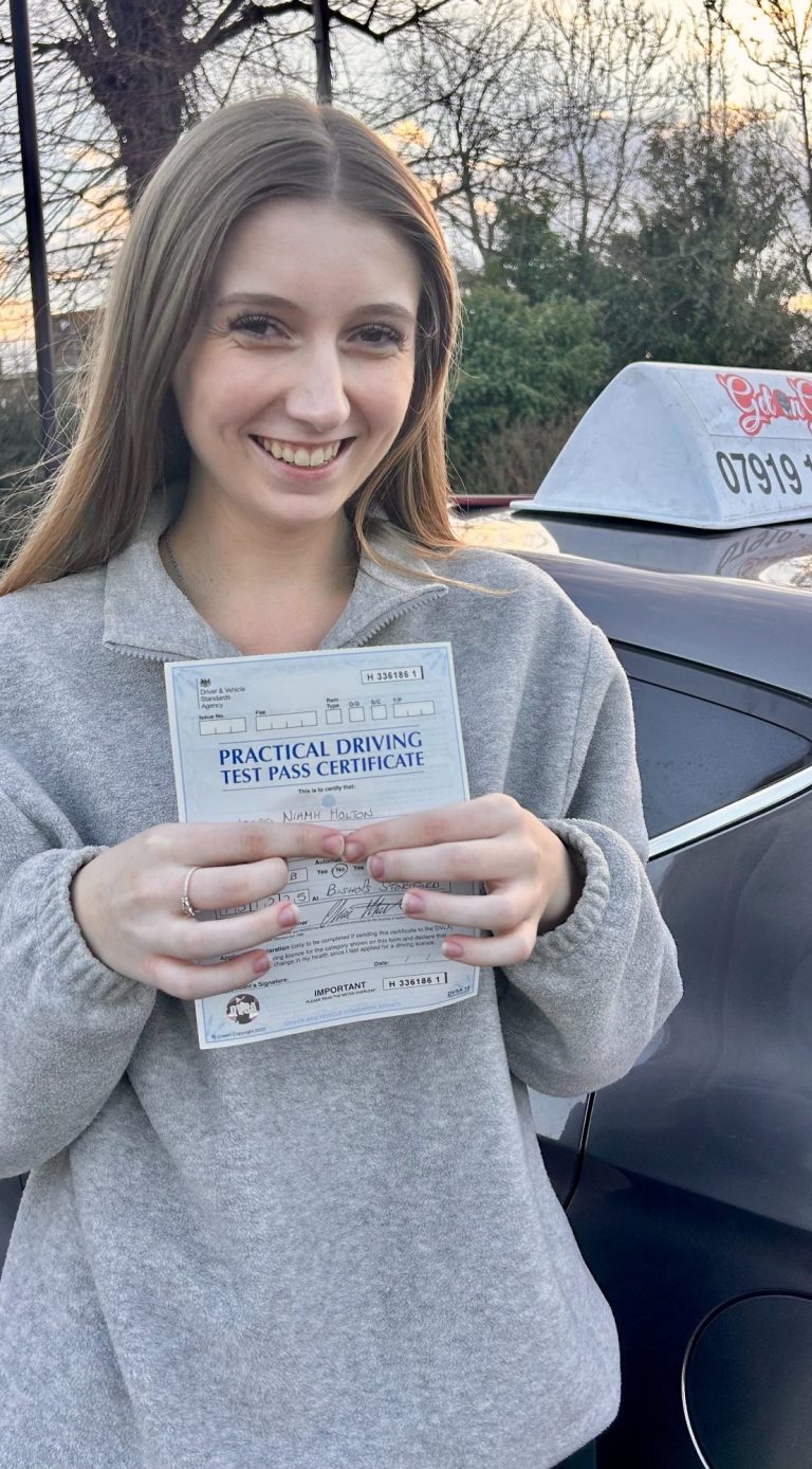 An image of a student holding her driving test pass certificate