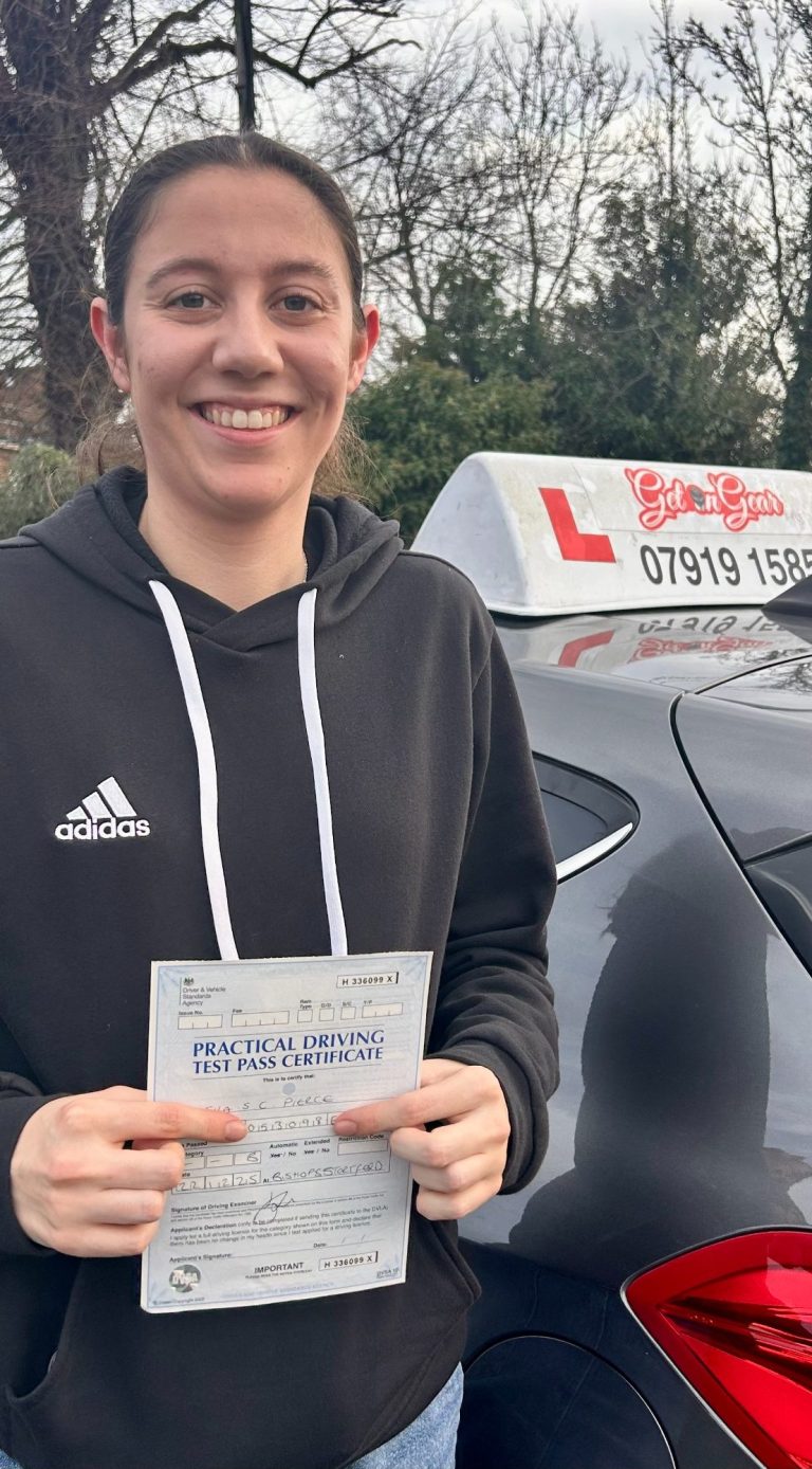 An image of a student holding her driving test pass certificate