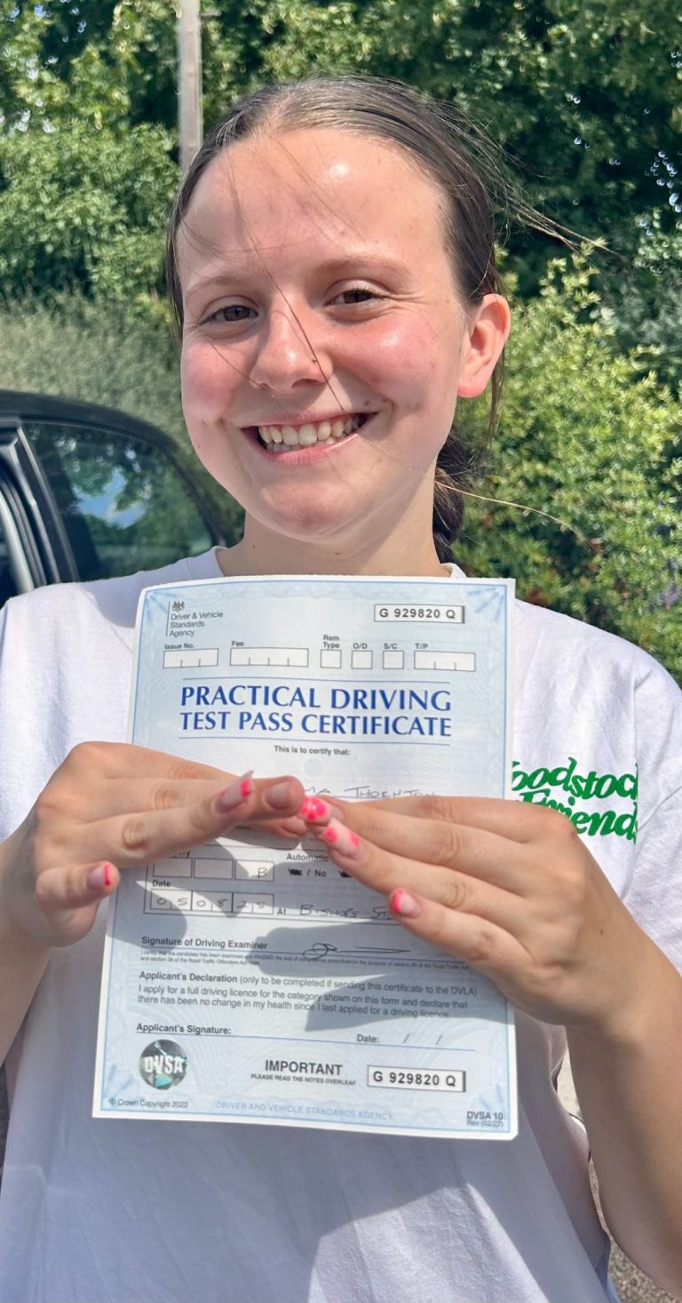 An image of a student holding her driving test pass certificate